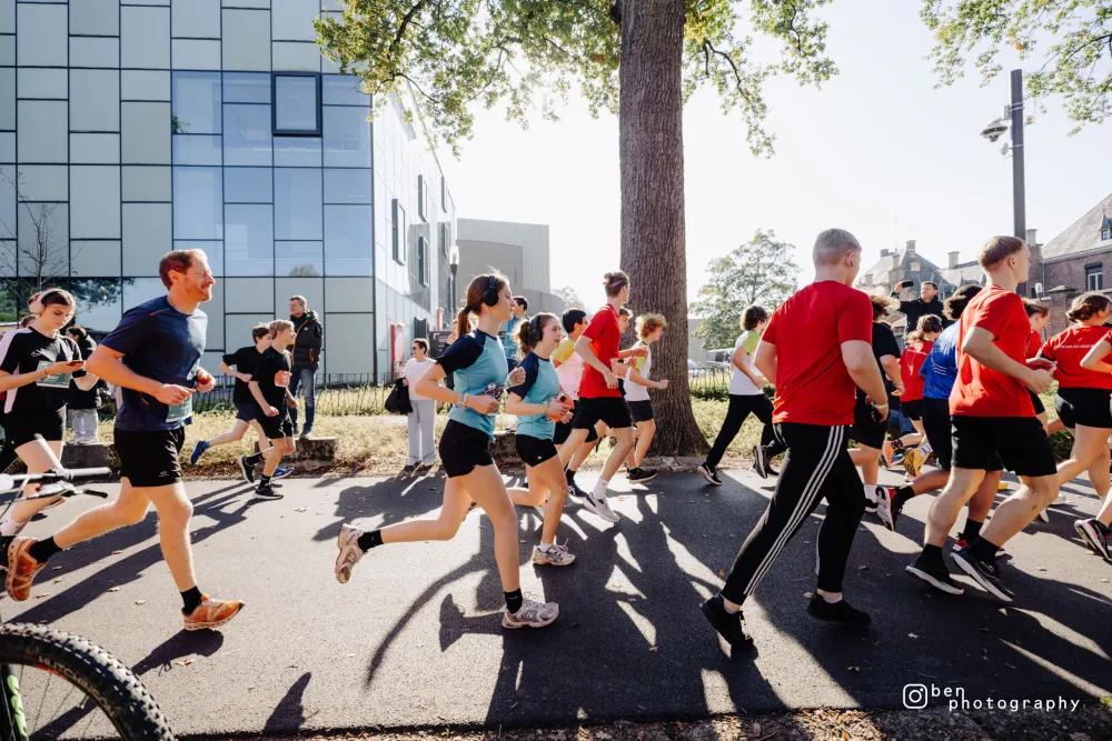 Lopers passeren het glazen campusgebouw